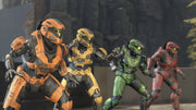 Four Halo Spartans in orange, yellow, green, and red armor facing off in Halo multiplayer
