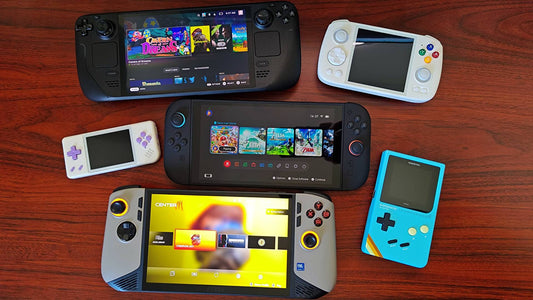 Collection of handheld gaming consoles displayed on a wooden surface, including modern and retro devices with colorful screens and controls arranged neatly.