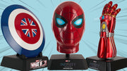 Marvel replica collectibles on display stands featuring Captain Carter’s shield, an Iron Spider mask, and an Iron Man nano gauntlet against a light blue background.