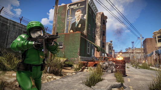 A gameplay screenshot from Rust showing a player in a green hazmat suit aiming a rifle down a post-apocalyptic urban street with burning cars and a worn billboard in the background.