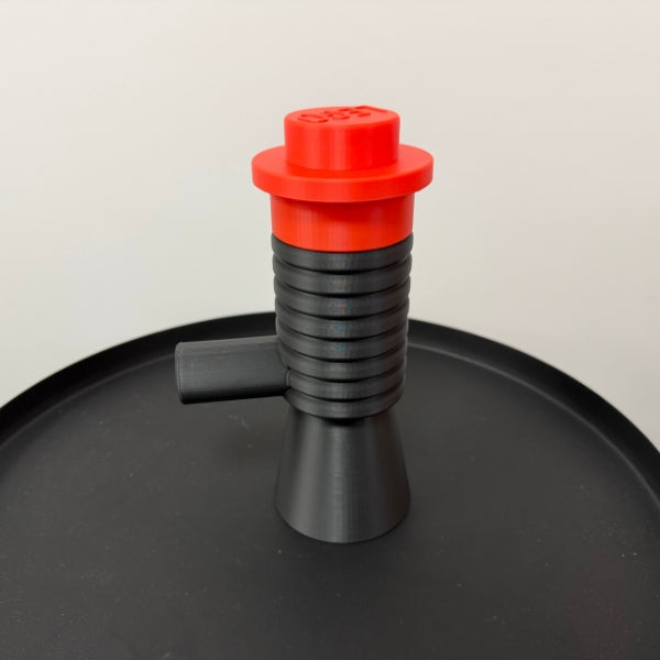 Brick style megaphone blaster replica with red top piece, 3D printed toy inspired prop displayed on table.