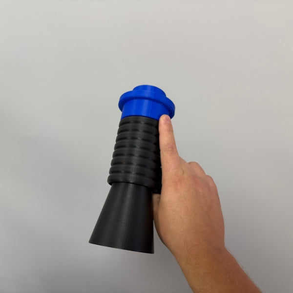 Hand pointing to removable top piece on brick style megaphone blaster replica.