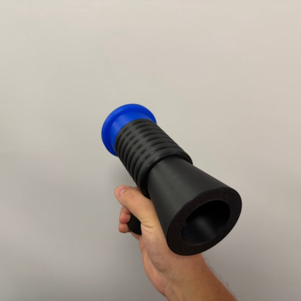 Brick style megaphone blaster replica held in hand showing front barrel opening.