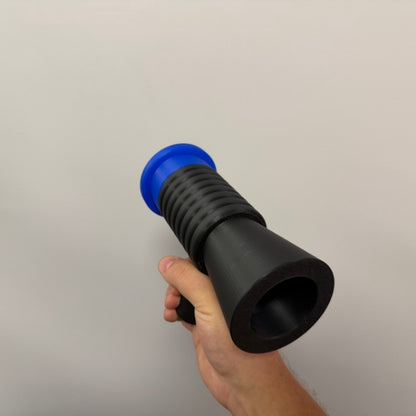 Brick style megaphone blaster replica held in hand showing front barrel opening.