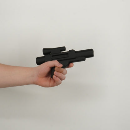 Black brick style blaster replica held in hand showing life size scale of the 3D printed prop.