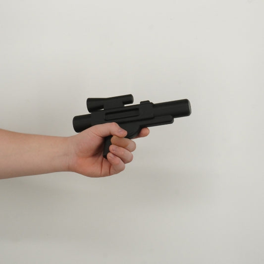 Black brick style blaster replica held in hand showing life size scale of the 3D printed prop.