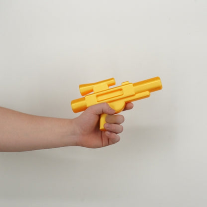 Yellow brick style blaster replica held in hand demonstrating the size of the 3D printed toy inspired prop.