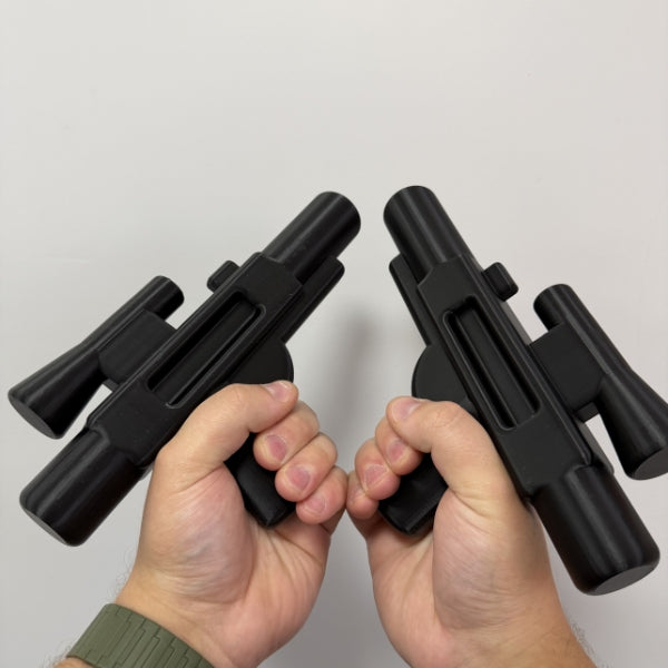 Two black brick style blaster replicas held in both hands showing the size of the 3D printed prop.