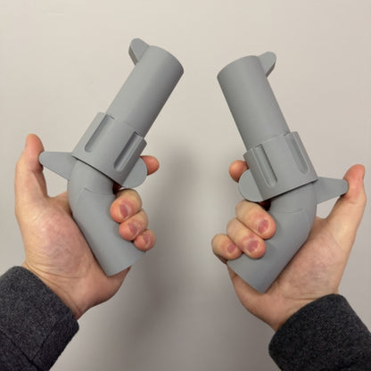 Two gray brick style revolver replicas held in both hands showing the life size 3D printed props.