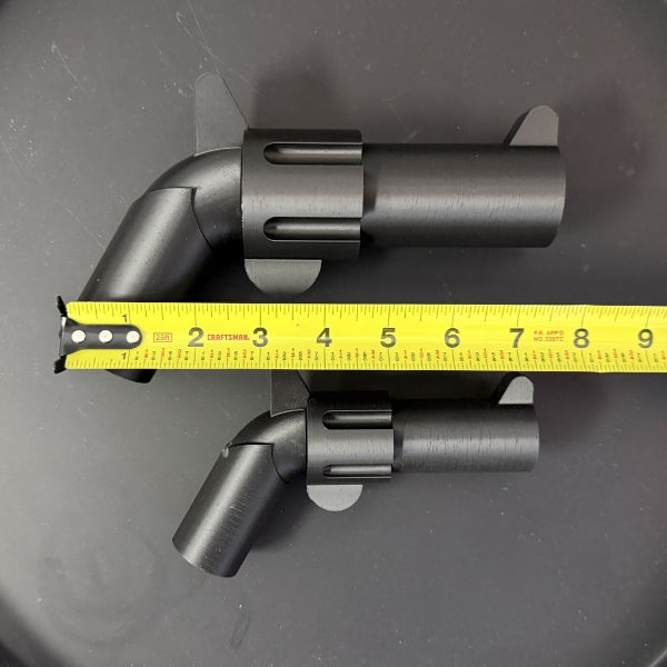 Brick style revolver replicas with tape measure showing size difference between large and small versions.