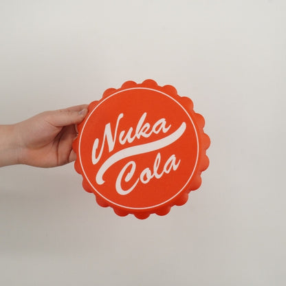 Nuka Cola bottle cap wall hook replica inspired by Fallout held in hand showing the size of the 3D printed wall decor prop.