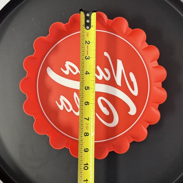 Top view of Nuka Cola bottle cap wall hook replica with tape measure showing full width of the prop.